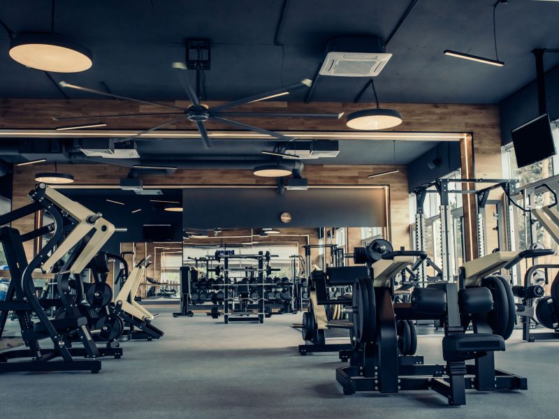 Modern light gym. Sports equipment in gym. Barbells of different weight on rack.